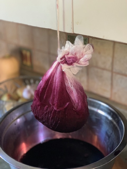 straining the grape pulp for juice for grape jelly